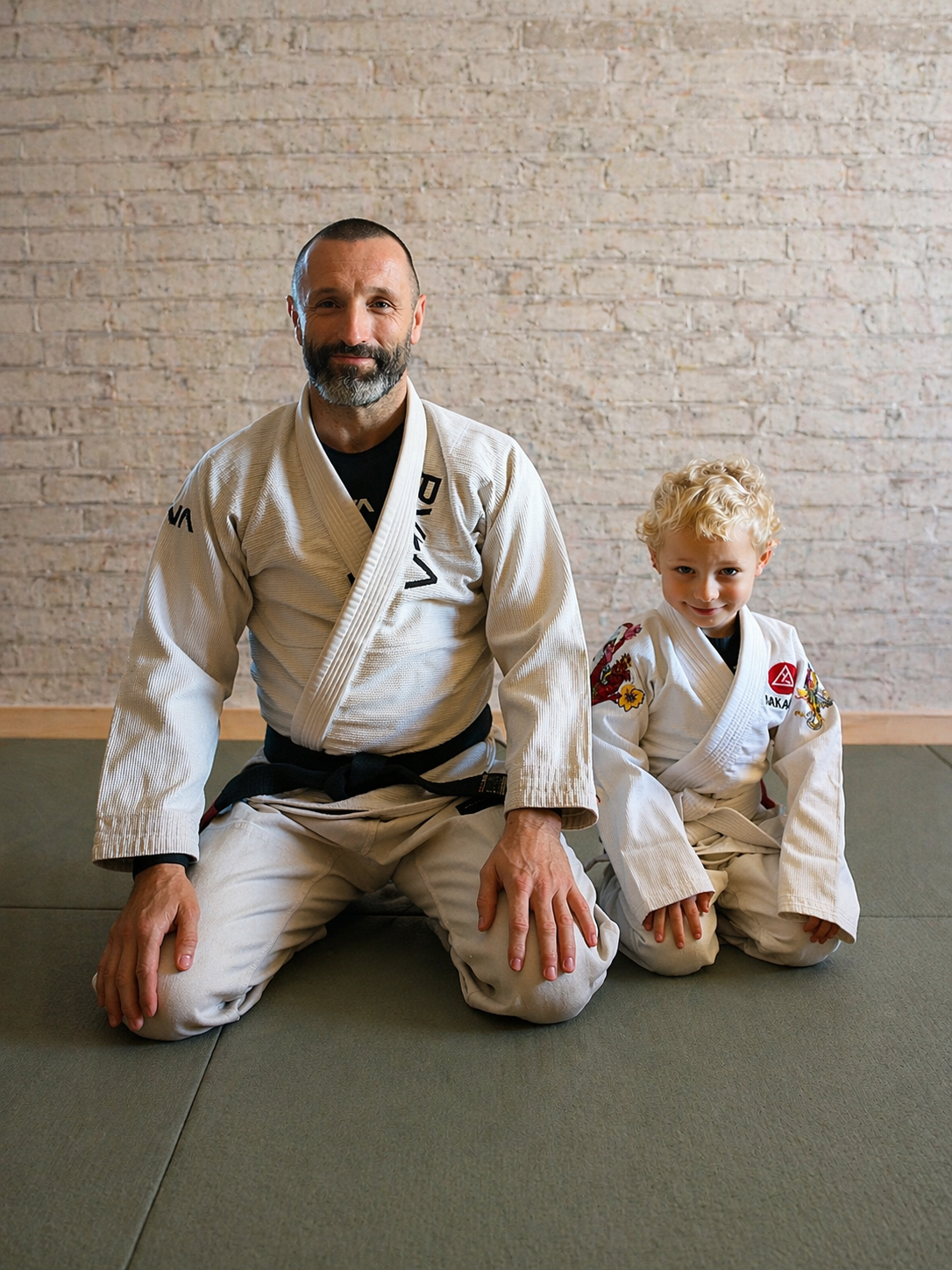 Wilson Meloncelli with his son Leonides, both in white jiu-jitsu gis, on the mat